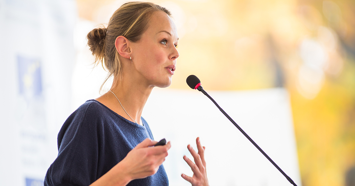 Woman-speaking-microphone Woman-speaking-microphone
